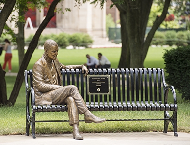 Dr Thomas Starzl bronze sculpture sitting on park bench on Cathedral of Learning lawn